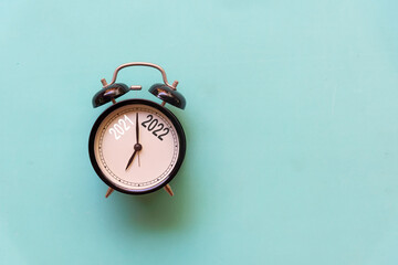 2021 and 2022 on black alarm clock on blue background.  Merry Christmas and Happy new year concept....