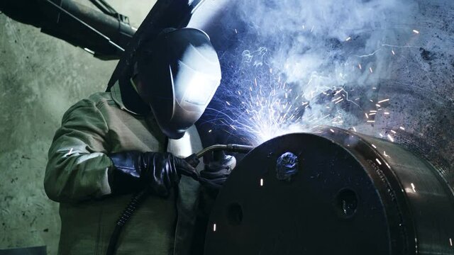 A welder is working in a factory
