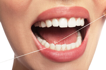 Woman flossing his teeth on white background, closeup. Dental care