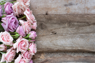 Pink roses on a wooden background. Postcard for congratulations. Flowers for the background.