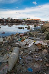 River and village landscape view with plastic garbage floating and drifting in the sea canal in Cebu, Philippines