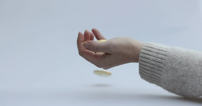 Male hand puts a cryptocoin, Bitcoin or BTC, in a woman's hand, depicting earning or paying with crypto or cryptocurrency and saving, holding or hodling. High quality 4k footage