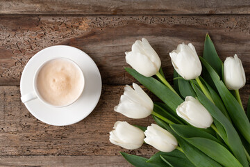 White tulips on a wooden background. Letter for congratulations. Card. Bouquet of white flowers. 