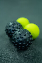 Black and green massage balls on a black background in the gym