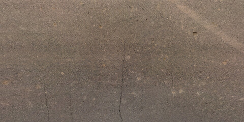 view from above on surface texture of old asphalt road with cracks