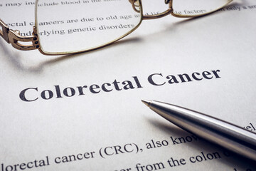 Info about colorectal cancer and pen with glasses.