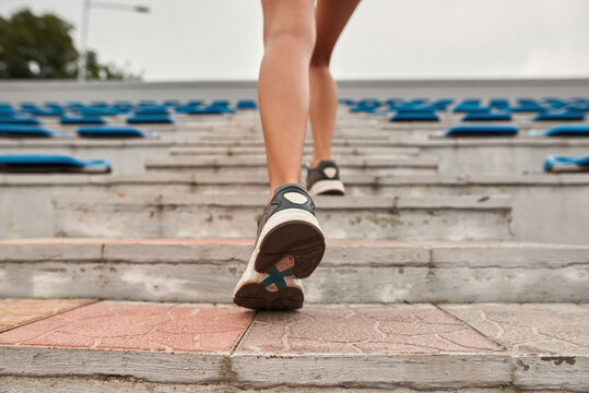 Cropped image of sports woman running on stairs
