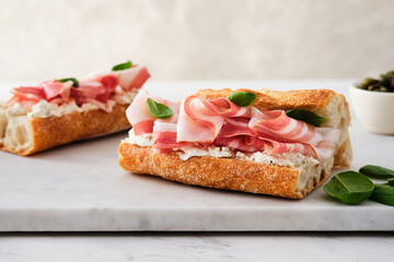 Ciabatta Sandwich with Jamon Serrano and spinach, on white background.
