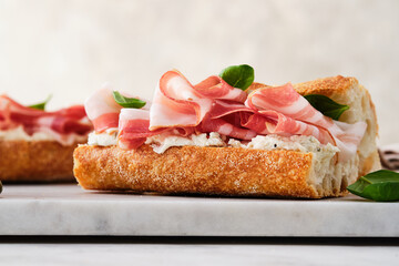 Ciabatta Sandwich with Jamon Serrano and spinach, on white background.