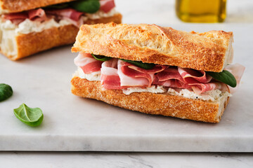 Ciabatta Sandwich with Jamon Serrano and spinach, on white background.