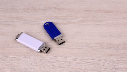 Two flash drives on a wooden table