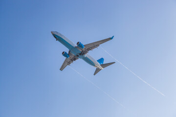 Fototapeta na wymiar the plane flies against the background of the blue sky
