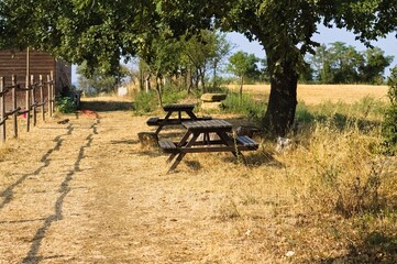 Two wooden picnic tables in the Italian countryside (Umbria, Italy, Europe) - 470665584