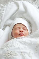 Newborn baby sleeps in beautiful elegant clothes in a letterhead