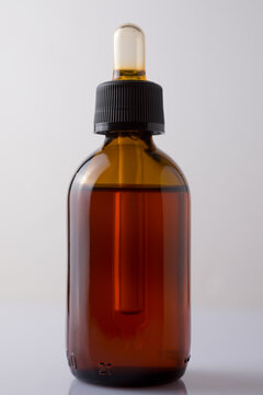 Liquid devil's claw in a brown glass container with a dispenser on a white background