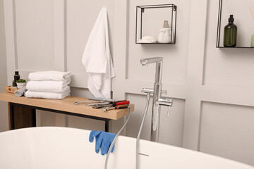Fototapeta na wymiar Professional plumbing tools and installed water tap in bathroom