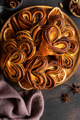 Sweet homemade cinnamon rolls in the shape of a heart on an old retro style. New Year mood. Traditional Swedish cinnabons. Selective focus