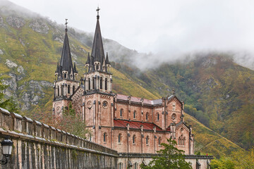 Fototapeta na wymiar Picturesque red stone basilica and mountains in Covadonga. Cangas, Asturias