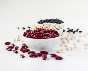 Assortment of beans in a white bowl on white background