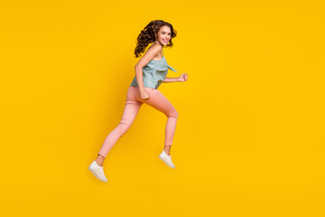 Fototapeta na wymiar Full body photo of cheerful young woman jump up run empty space news isolated on yellow color background