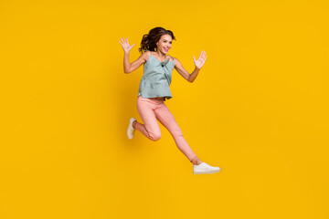 Fototapeta na wymiar Full body photo of energetic positive woman jump up raise hands enjoy empty space isolated on yellow color background