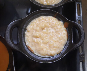 Close-up of homemade rice pudding in a mini casserole dish with black handles