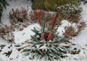 Geschmücktes Grab im Winter mit Schnee