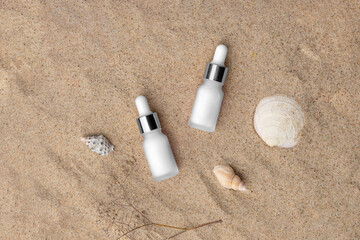 Cosmetics branding mockup template, real photo, dropper, tube, bottle blank isolated on a sea sand background with shells to place your design.