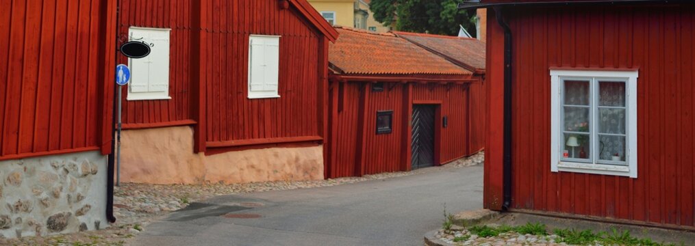 Traditional swedish houses colored with falu red dye. Tiled roofs. Empty street. Str&auml;ngn&auml;s, M&auml;laren lake, Sweden. Travel destinations, landmarks, sightseeing, vacations, recreation, estate, home