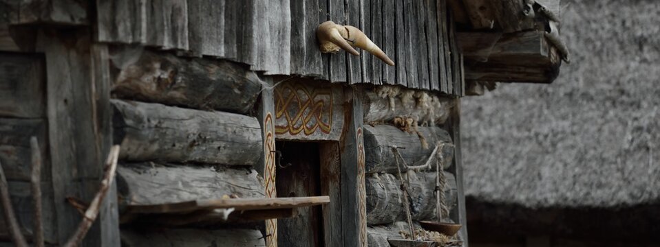 Traditional viking age village. Birka, Bj&ouml;rk&ouml; island, lake M&auml;laren, Sweden. Wooden house (log cabin) exterior, skull. Atmospheric landscape. Landmarks, tourism, history, historical reenactment, craft
