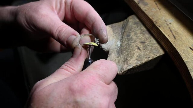 Closeup of wedding ring polishing by caicasian jeweler isolated, 4k footage