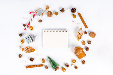 Fototapeta na wymiar An empty notepad for your text in the center of Christmas items on a white background. Holiday card for Christmas and New Year. Copy space