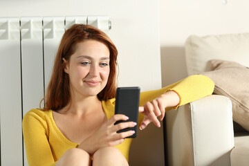 Happy woman cheking phone sitting at home