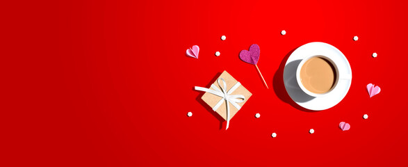A cup of coffee with a gift box and hearts - flat lay