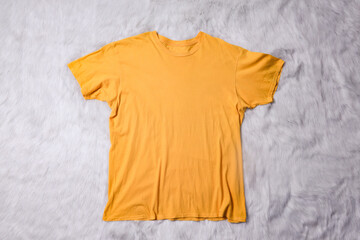 Yellow t-shirt mockup on grey background. Flat lay tee template