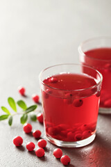 Fresh cranberry drink in a glass and berries on the table. Tonic medicinal drink.