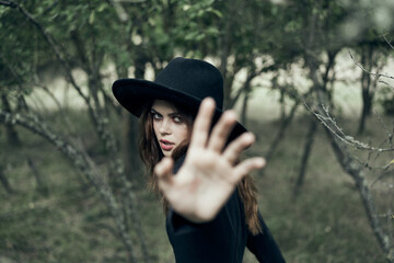 woman in a black hat gesturing with her hands witch magic fantasy