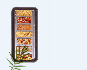 Natural granola cereal bars with nuts, seeds, oats, berries and dry fruits on a blue background...