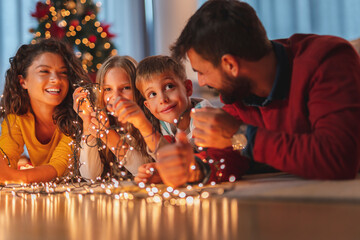 Obraz na płótnie Canvas Parents and children spending Christmas Eve together at home