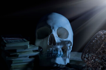 Skull, crown and money against black background as death and end of human life. Horizontal image.