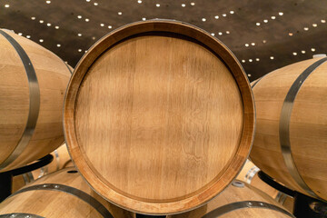 New oak barrel with stainless steel rings in a winery for making wine. End view. Advertising, copy ...
