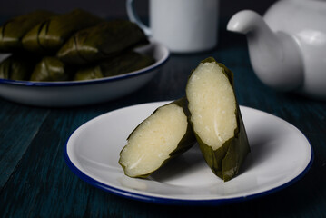 Cassava cake, known as katimus in West Java,Indonesia. Katimus made of compressed cassava cake in the form of a cylinder wrapped inside banana leaf then steamed. White is savory while brown is sweet