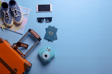 Flat lay of travel or holiday concept with copy space on blue background
