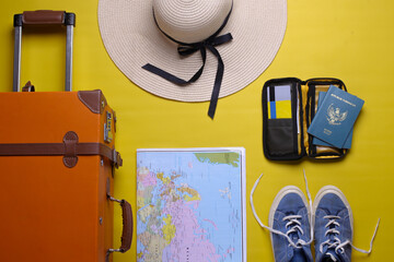 Flat lay of various traveler or holiday accessories on yellow background 