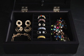 Fototapeta na wymiar Jewelry box with stylish bijouterie on black table