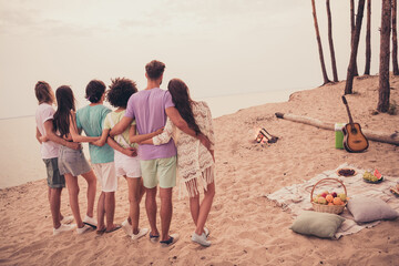 Rear back behind view of attractive carefree people buddy fellow meeting hugging peaceful day at beach outdoors