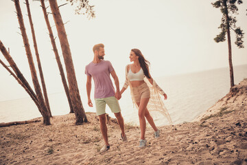 Photo of carefree cheerful couple lovers hold hands go sand wear casual outfit nature seaside beach...