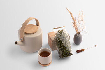 Transparent tea bag packaging with tea, teacup, dried plants, pot, sugar stick, on a white...