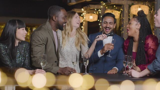 Sliding Shot of Friends Singing Group Karaoke During New Years Celebrations