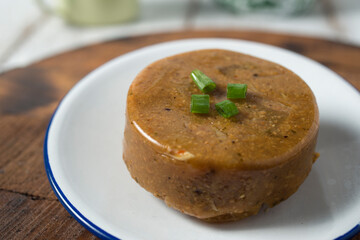 Cow skin meat cooked with spicy peanut sauce with onion leaves as garnish. The dish was cooled and mold like pudding.